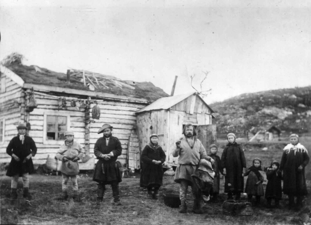 Familien Ole Persen Savio og Jon Andersen Must foran Musts hus, Sandnes, Sør-Varanger, Finnmark, før 1900. Sjøsamer.