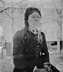 Kvinne sittende på gårdstunet, Lunden gård, Hegglandsgrend, 