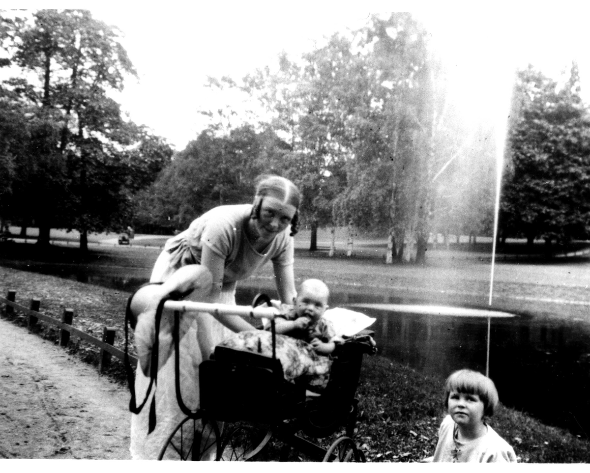 Kvinne med barn og barnevogn på tur ant. i Slottsparken, Oslo. Venner av familien Fossberg.