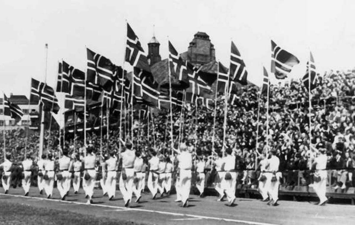 Fra Oslo under fredsdagene i 1945. Idrettens Dag på Bislett Stadion 3.juni. Idrettsmenn med flaggborg på den oppmerkede banen.