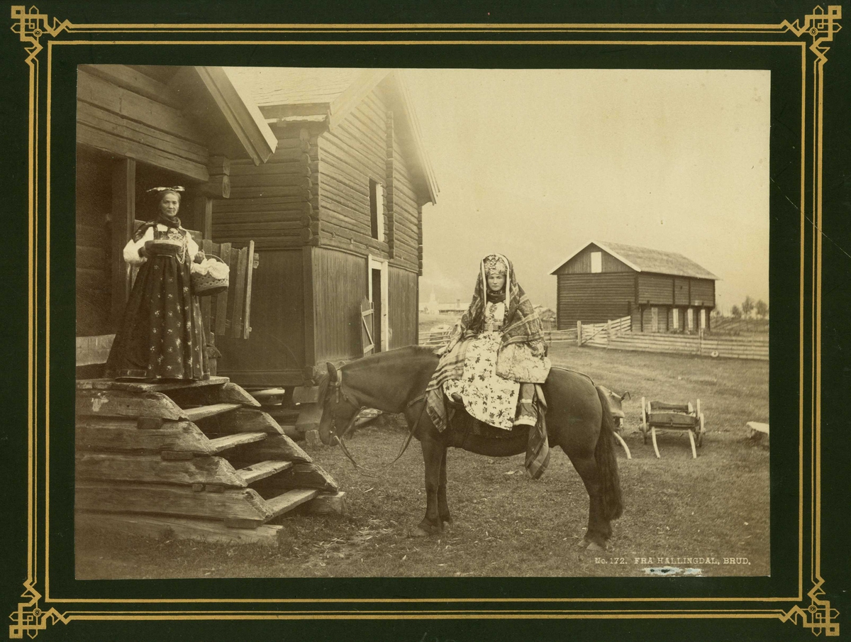 Kvinnedrakt, brud fra Hallingdal til hest på gårdstun, Buskerud. Kvinne står på toppen av stabburstrapp med ølbolle og kurv (av teger), ant. med bryllupsmat.
