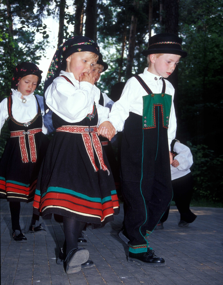 Norsk Folkemuseums dansegruppe, kledd i folkedrakter, danser folkedans i friluftsteateret NF 349.