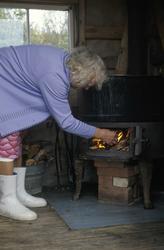 Inga Enodd fyrer i kjelringen i kokehuset på Endal seter.
K