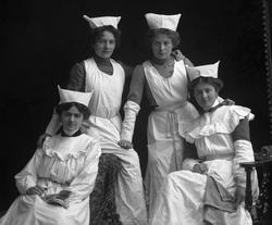 Gruppeportrett, fire jenter i uniform. Husstellselever? Fru 