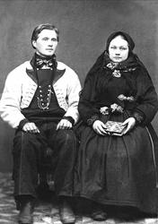 Gruppeportrett, ektepar i folkedrakt. Avfotografert 1908.