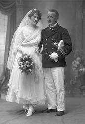 Gruppeportrett, bryllupsbilde. Kvinne i hvit kjole, mann i m