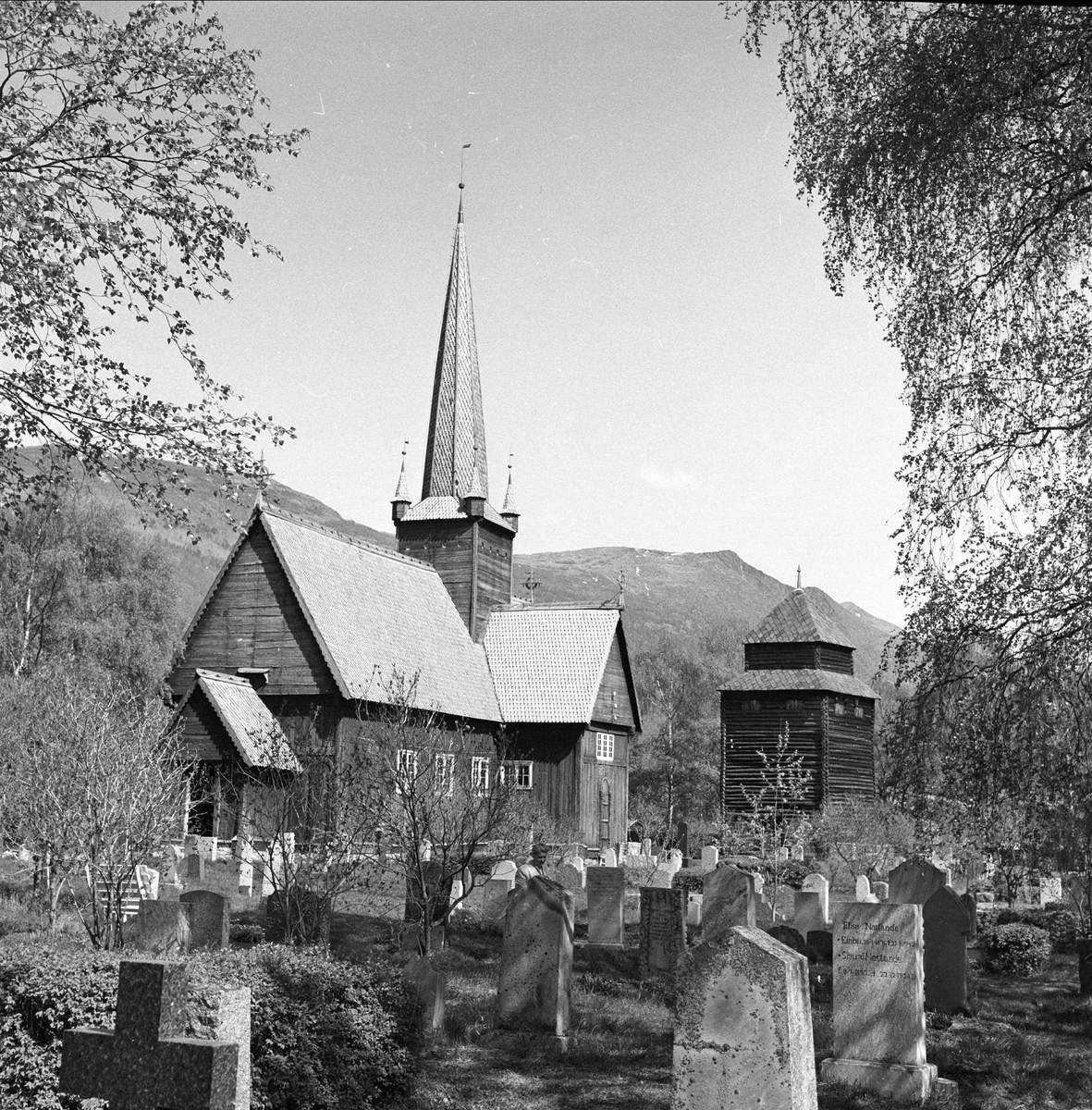 Vågå kirke, Oppland, juli 1957. Kirka og kirkegården.