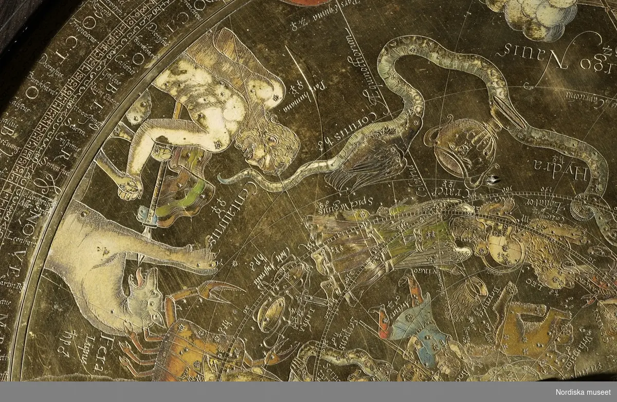 Armillarsfär med astronomiskt ur, av mässing, brons, stål, ebenholtz, Jost Bürgi/Antonius Eisenhoit, Kassel, 1585. Det astronomiska uret ligger i ett träfodral av ebenholtz på lejontassar av förgylld brons. På uret sitter en ursprungligen med uret kopplad armillarsfär. Uret är utrustat med tim- och minutvisare och har både juliansk och gregoriansk kalender. Med armillarsfären kan stjärnpositioner m.m.  avläsas. [Ulf Hamilton, 2007]
/Anna Arfvidsson Womack 2022
