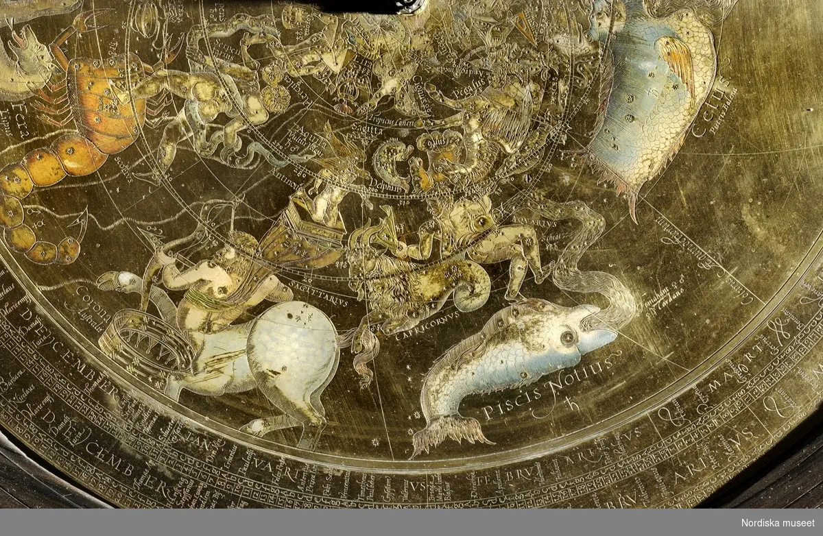 Armillarsfär med astronomiskt ur, av mässing, brons, stål, ebenholtz, Jost Bürgi/Antonius Eisenhoit, Kassel, 1585. Det astronomiska uret ligger i ett träfodral av ebenholtz på lejontassar av förgylld brons. På uret sitter en ursprungligen med uret kopplad armillarsfär. Uret är utrustat med tim- och minutvisare och har både juliansk och gregoriansk kalender. Med armillarsfären kan stjärnpositioner m.m.  avläsas. [Ulf Hamilton, 2007]
/Anna Arfvidsson Womack 2022
