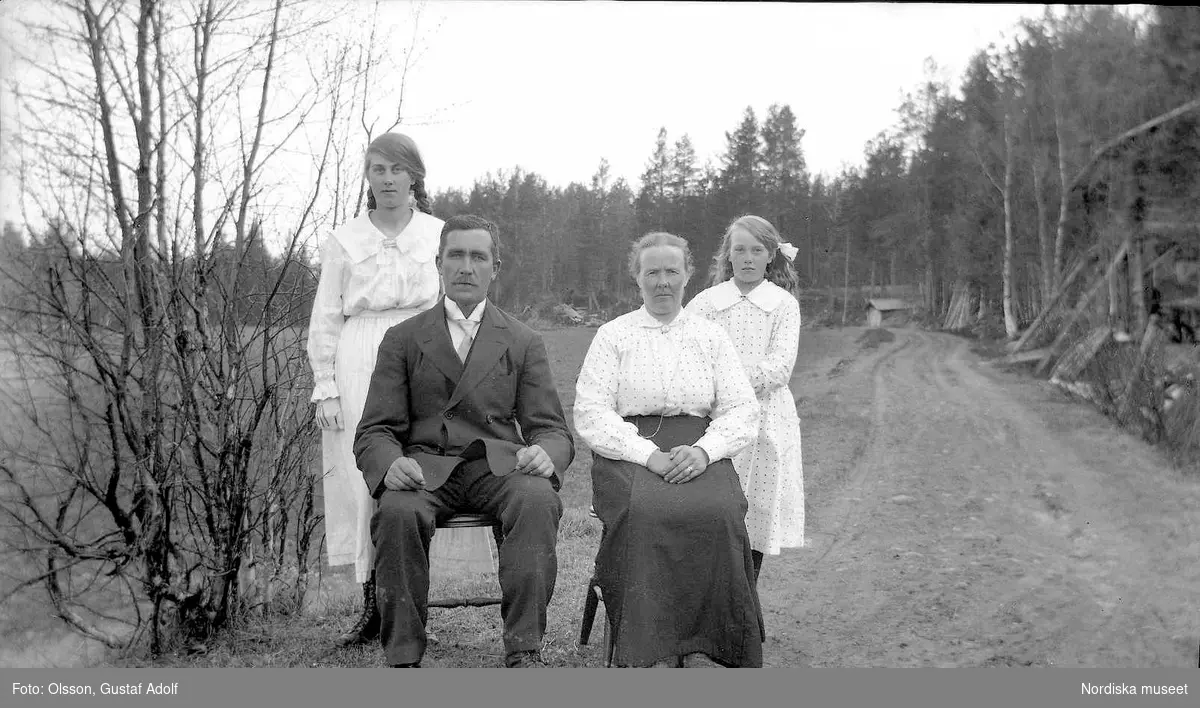 Familjebild tagen ute på vägen ca 1920. Mor, far och två döttrar. Enligt uppgift från Olle Tranberg, Transtrands Hembygdsförening är det:  August Hansson med hustrun Iljans-Klara Östensdotter Hansson, och döttrarna Ingeborg och Agnes Hansson. Familjen bosatt i Sörsjön, Djuptjärn.