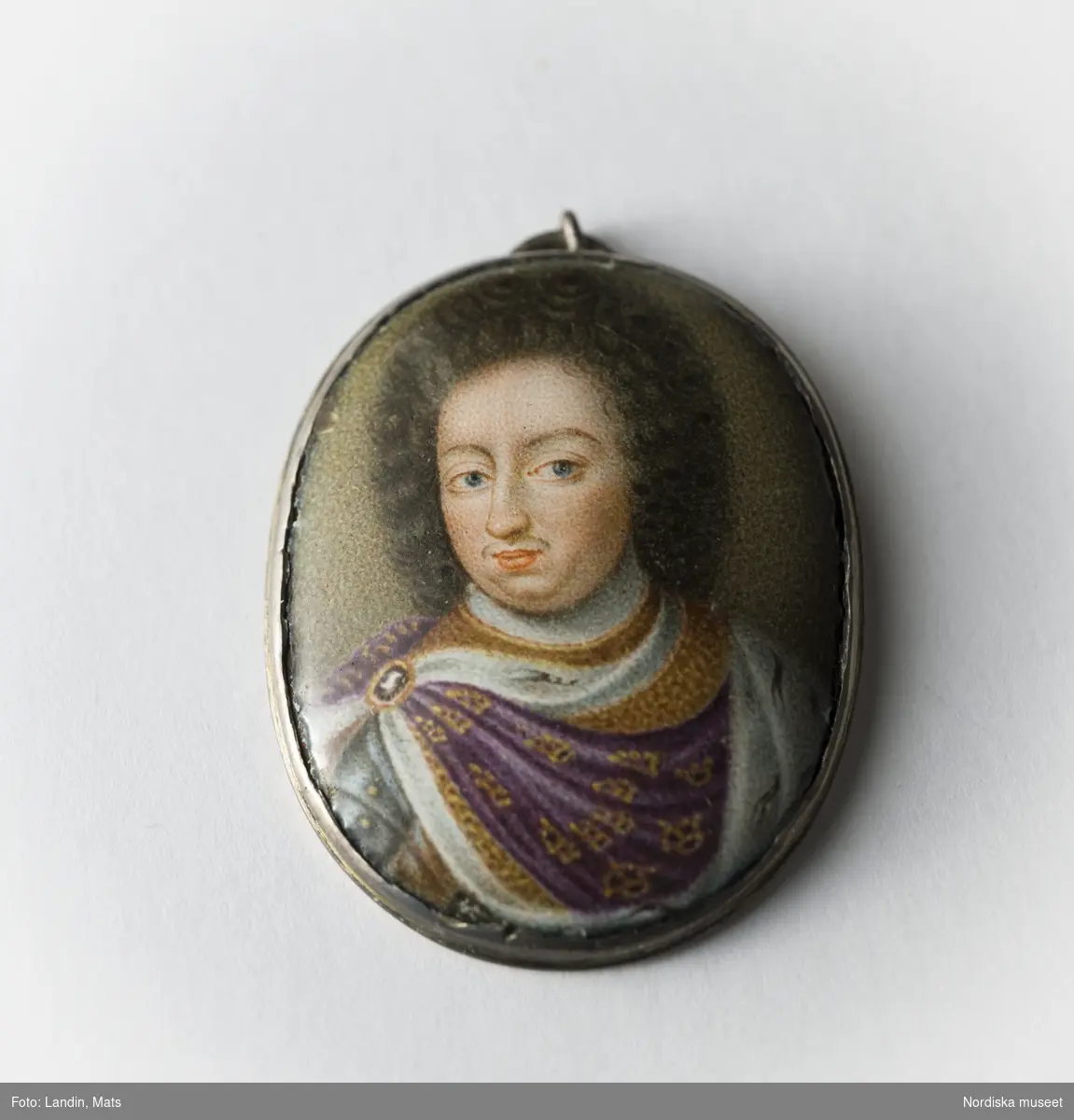 Miniatyrporträtt i emalj föreställande Karl XI (1655-11-24-1697-04-05) med smycken. Föremål ur Nordiska museets samlingar invnr.148699.
Se även föremålsposten,  relaterade objekt.