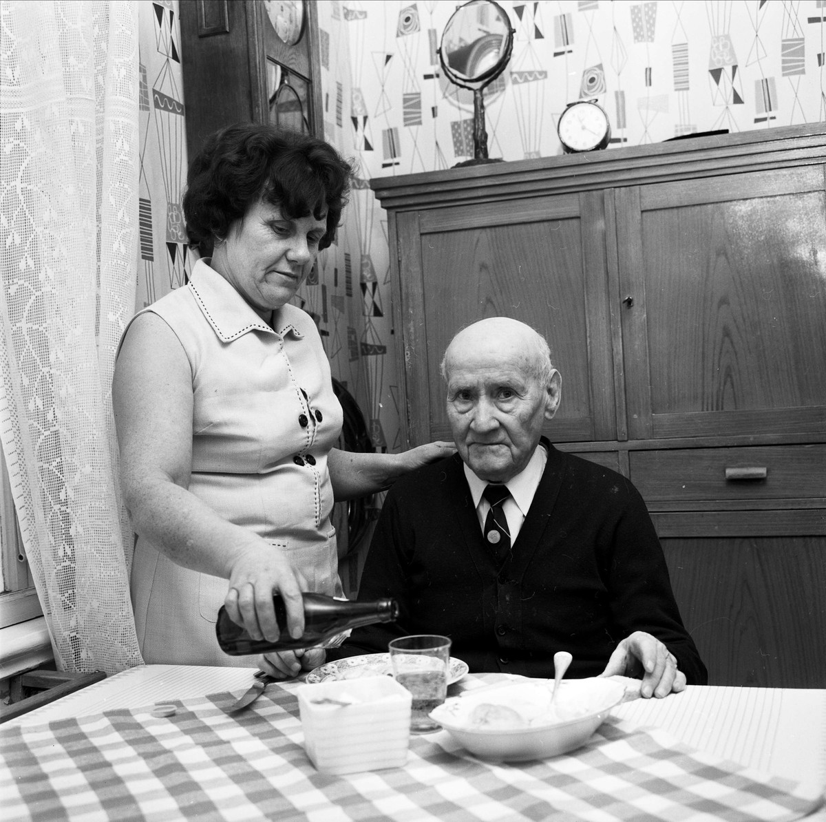 Förre köpmannen Manne Pettersson i Tierp fick 1967 en
timmes tillsyn varje dag av hemsamariten Fanny Pettersson.
Hon var en av 18 hemsamariter i Tierps köping. De fick
framför allt hjälpa till med städning, matlagning och
bakning.
”Hemsamariterna hade fått en viktig uppgift att
fylla i dagens samhälle”. Deras insatser avlastade
ålderdomshemmen och gav de äldre möjlighet att
bo kvar i sina bostäder.