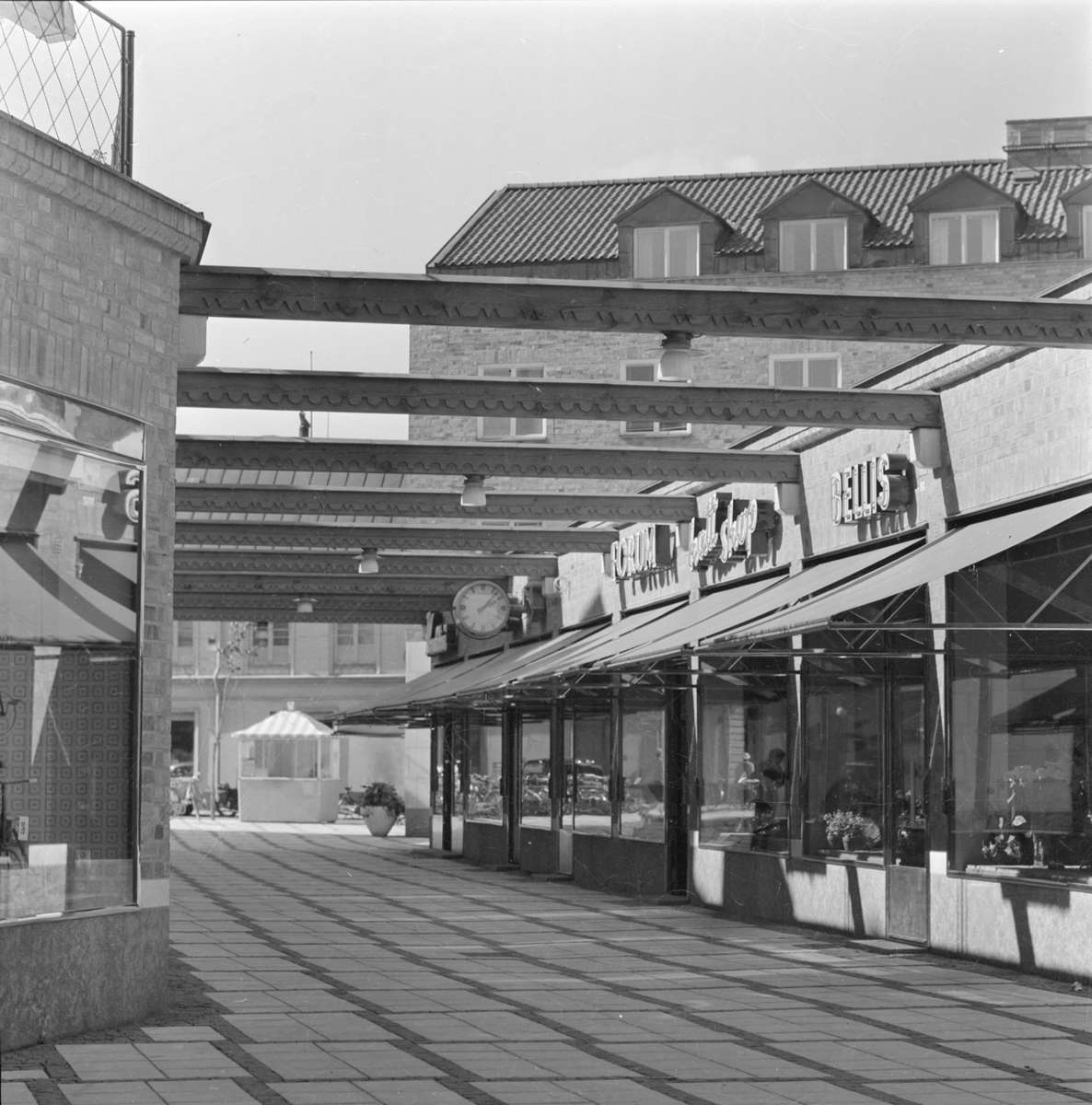 Affärsgata i kvarteret Pantern med Forums skivaffär och Bellis blomsterhandel, Dragarbrunn, Uppsala efter 1953