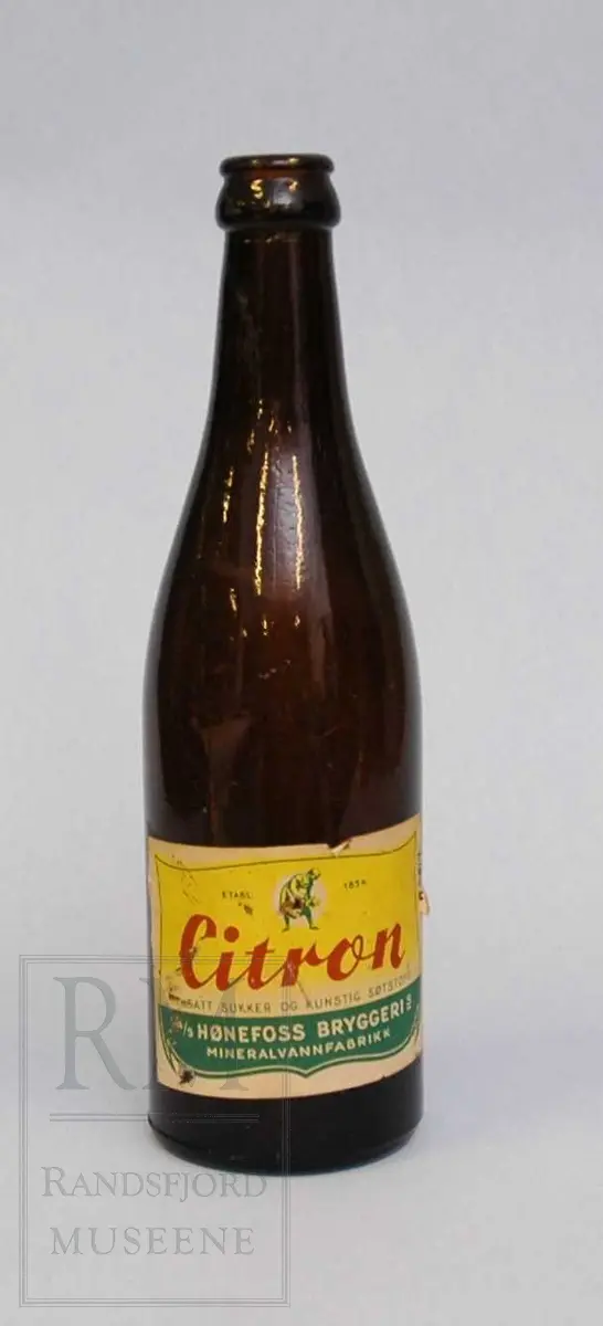 Flaske i brunt glass, med etikett. 