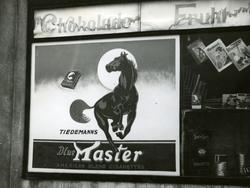 Reklame for Blue Master sigaretter i butikksvindu.