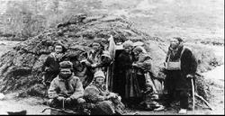 Gruppebilde av samer, utfor en gamme.