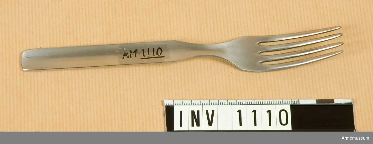 Samhörande nr är 1074-1129, (1109-1111).
Gaffel m/1929.
Utförd i ett stycke med fyra taggar. Förvaras under förvaring och transport instucken i skeden tillsammans med kniven. Något speciellt märke för GENSE finns ej på skeden, endast kniven. Har tillhört mob.utrustning vid Armémuseum.