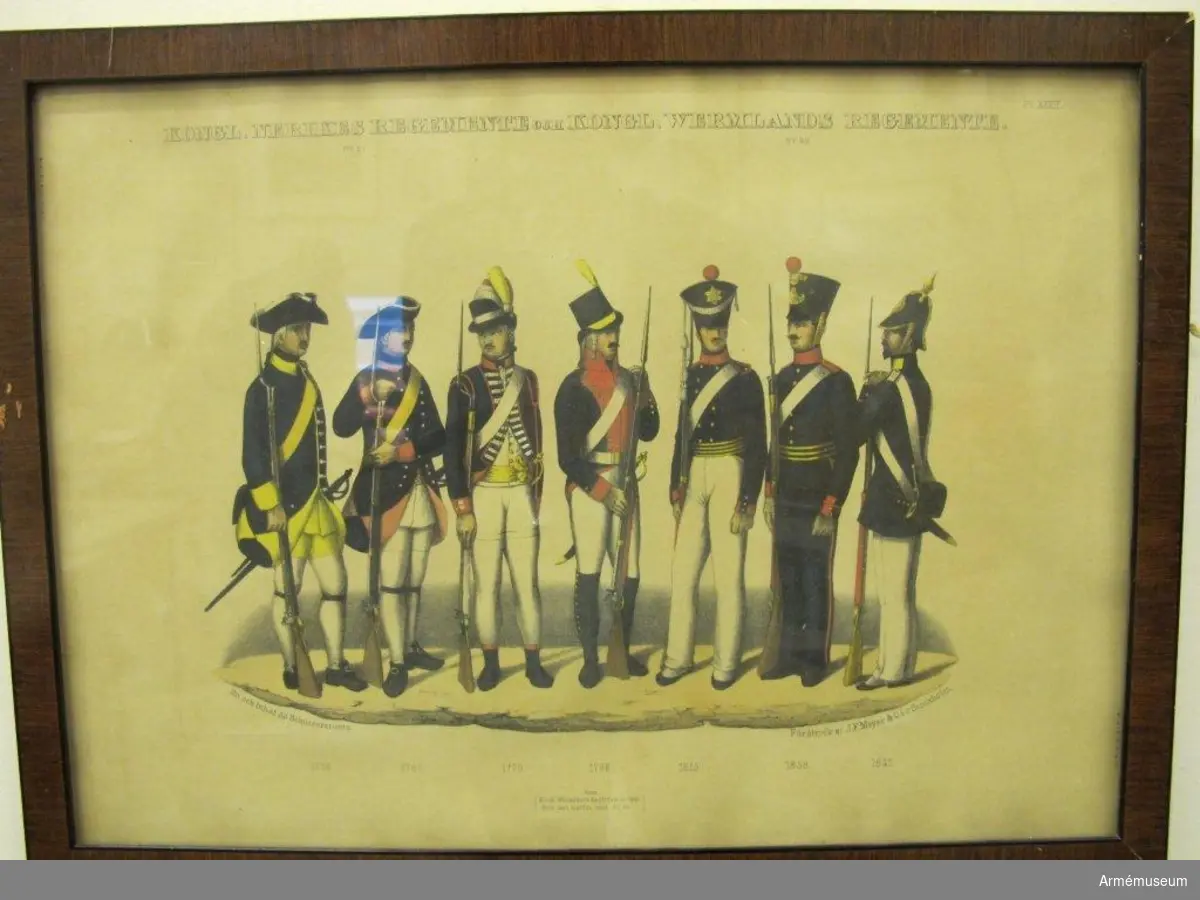 Tavla med uniformstryck av Schützerkrantz. Färgtrycket föreställer sju uniformer från Nerikes regemente och Wermlands regemente. Uniformerna föreställer modeller från åren 1756, 1765, 1779, 1798, 1815, 1838 och 1845. Uniformstrycket är glasat och har en mörk mahognyram ca 20 mm bred.