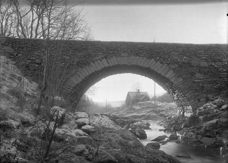 Text som medföljde bilden: "1937. 23. Stenbron och stugan tagit nere vid älven." 

Uppgifter från Munkedals HBF: "Gamla stenbron. Munkedalsälven. Snickarbostaden".