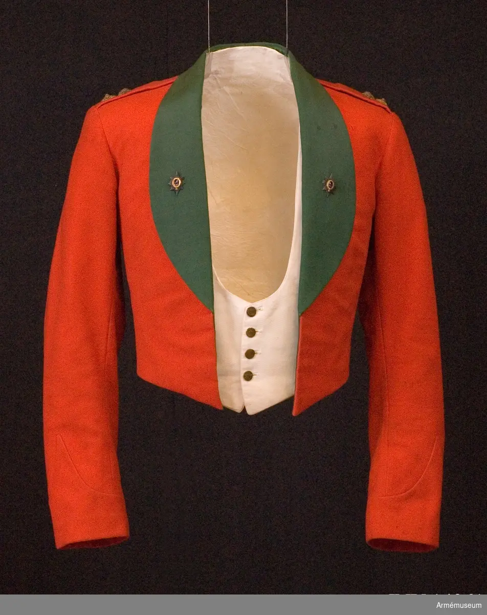 Grupp C I.
Del av mässuniform för överstelöjtnant vid The Worcesterhire Regiment i England: "scarlet shell jacket" med två regementsmärken.
Enligt "Dress regulations 1900" av W. Y. Carman fastställdes denna jacka 1896-07-17. 
Förmodad gåva från Lt Col P. H. Graves-Morris D.S.O. M.C.  Engelsk militärattaché i Sthlm.