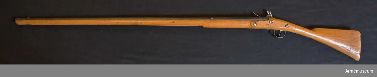 Grupp E XIV.
Afrikanskt gevär med flintlås. Loppets relativa längd är 72,4 kal. Rörkor och laddstock saknas. Låset signerat "BARKER".