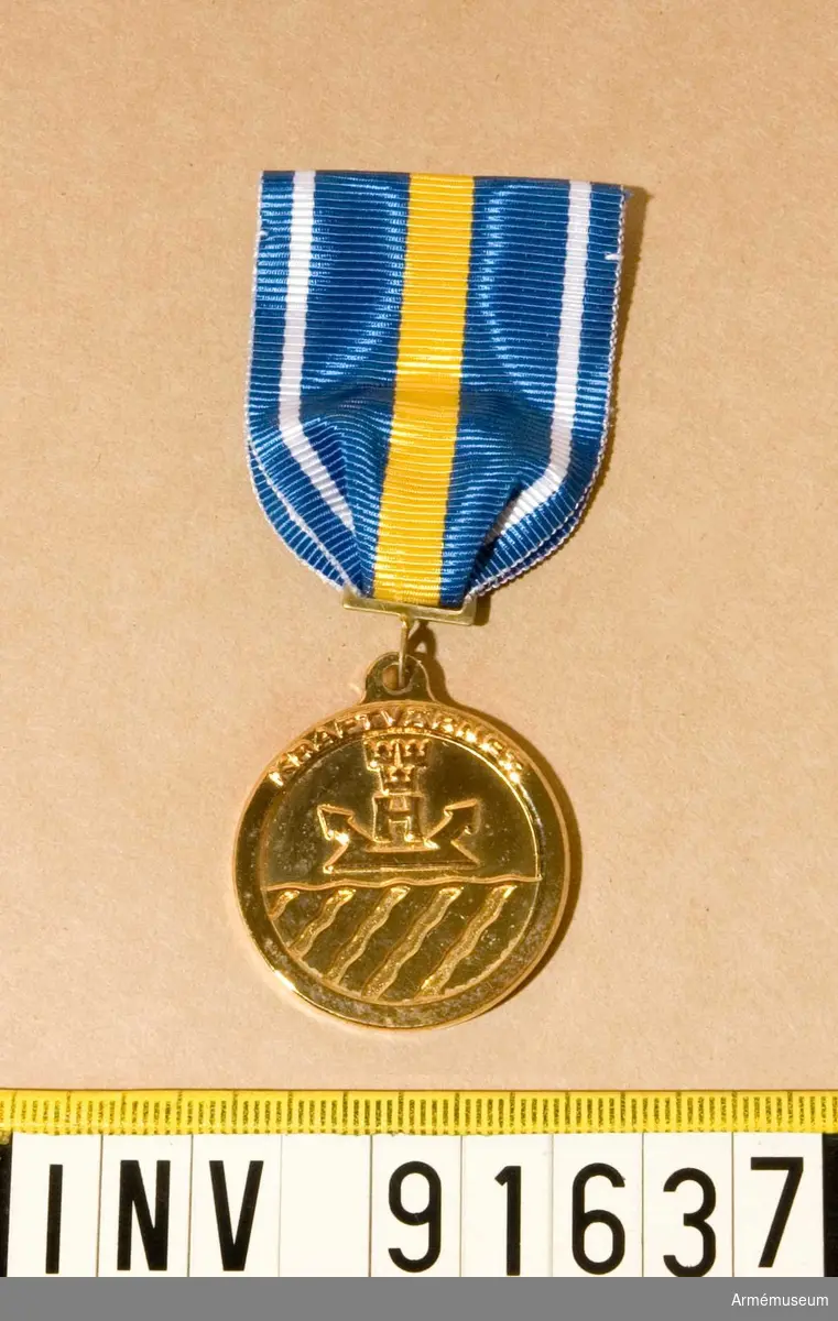 Medalj i guld. KraftvGM. 
På framsidan Kraftvärnets vapen och text. På baksidan en krans och text.  
Band i blått med vit rand på vardera sidan och en bred gul rand på mitten.