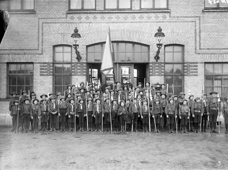 Enligt tidigare noteringar: "Scouter i uniform framför järnvägsstation i Uddevalla."