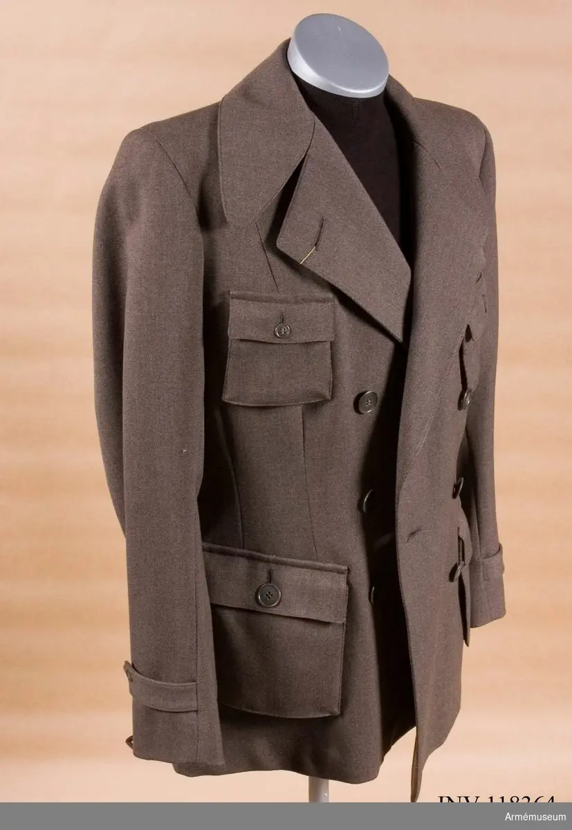 Jacka av gråbrunt diagonaltyg med bälgfickor, tillhörande uniform m/Rk 41 för kvinnlig Röda korset-personal.
Uniformen består i sin helhet av jacka, helknäppt kjol, väst, blus, mössa, armbindlar 2 st, munskydd 2 st.