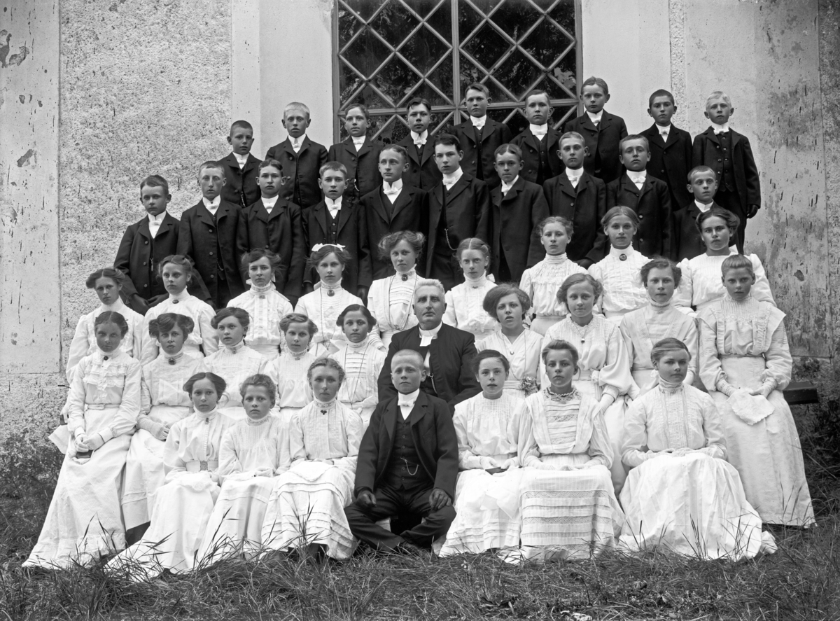 Konfirmandgrupp vid Simtuna kyrka, Uppland, 23 juni 1911. I mitten kyrkoherde August Hylander (1852-1935).