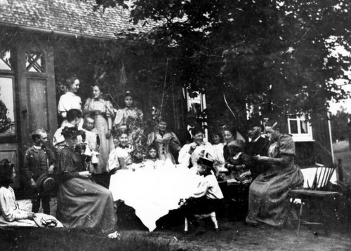 Kyrkoherde C A Josefson med familj och vänner en em vid kaffebordet utanför trädgårdsverandan. Omkring 1895. Breareds prästgård.