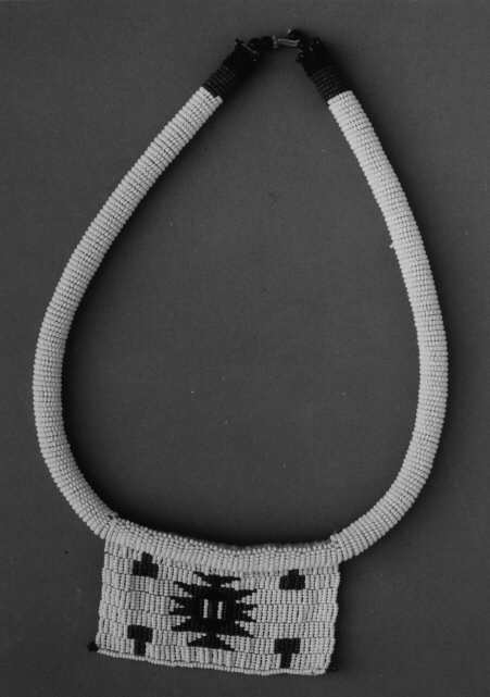 Pärlbrev, kärleksbrev från Umpumulo, Sydafrika. Föremålet är ett halsband med en rektangulär platta av pärlor. Färgerna på pärlorna, den ordning de har eller de mönster som uppstår har olika betydelser. Mottagaren tolkar brevets budskap och kan sedan bära det med sig, vanligen som ett smycke kring halsen.
Brevet utgöres av en rektangulär platta av pärlor, vars bottenfärg är vit med ett mönster i olikfärgade rektanglar, vilket utgör meddelandet. Plattan är fästad vid ett halsband, en tjock bomullssnodd, överklädd med småpärlor i nacken avslutad med fyra större pärlor, en rosafärgad ring av små pärlor samt en ögla av segelgarn för knäppning.