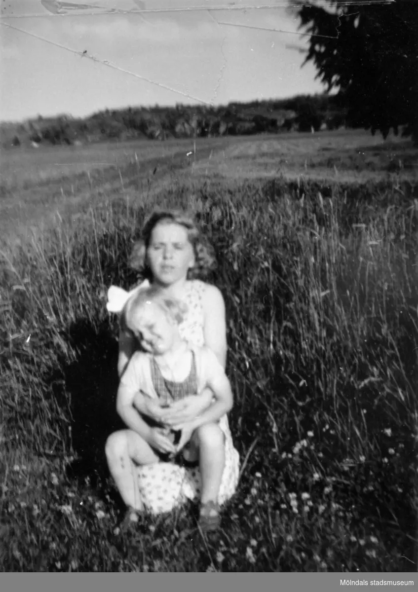 Inga-Lill Lipovsék 6 år, boende på Stretereds skolhem, troligtvis tillsammans med sin mamma på en sommaräng vid Stretereds skolhem, 1953. Ängen är där Sagåsens vårdavdelning byggdes.