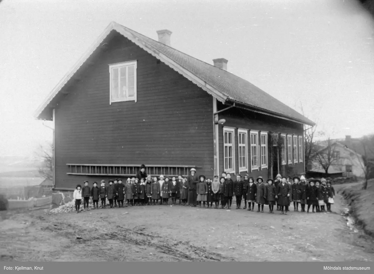Skolklass med lärarinna uppställda utanför Holtermanska skolan, före branden 1914.