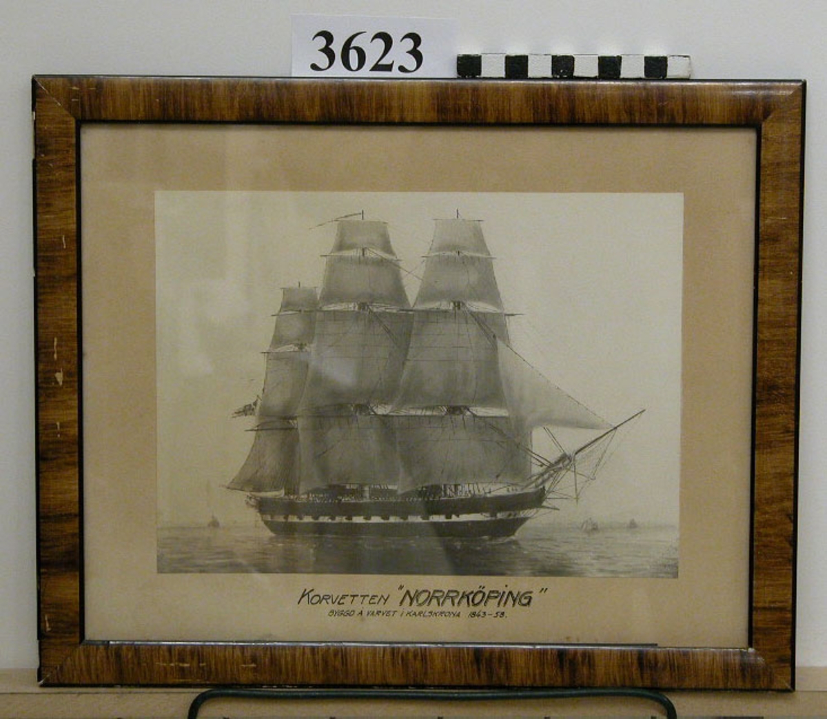 Fotografi, i glas och ram, av korvetten "Norrköping" till segels. Fartyget byggt på varvet i Karlskrona år 1848-58. Upphandlad år 1929 av Artilleridepartementet