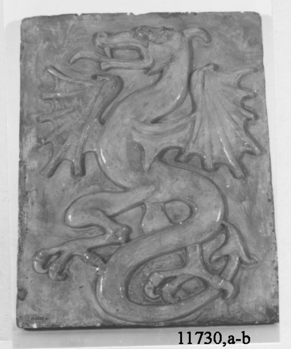Reliefen visar en drake färdig till anfall.
Emblem för styrbordssidan