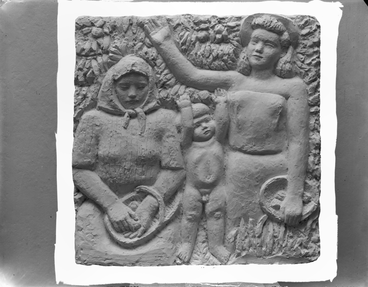 Reliefen "I trädgården" av Göran Strååt
Två kvinnor och ett barn