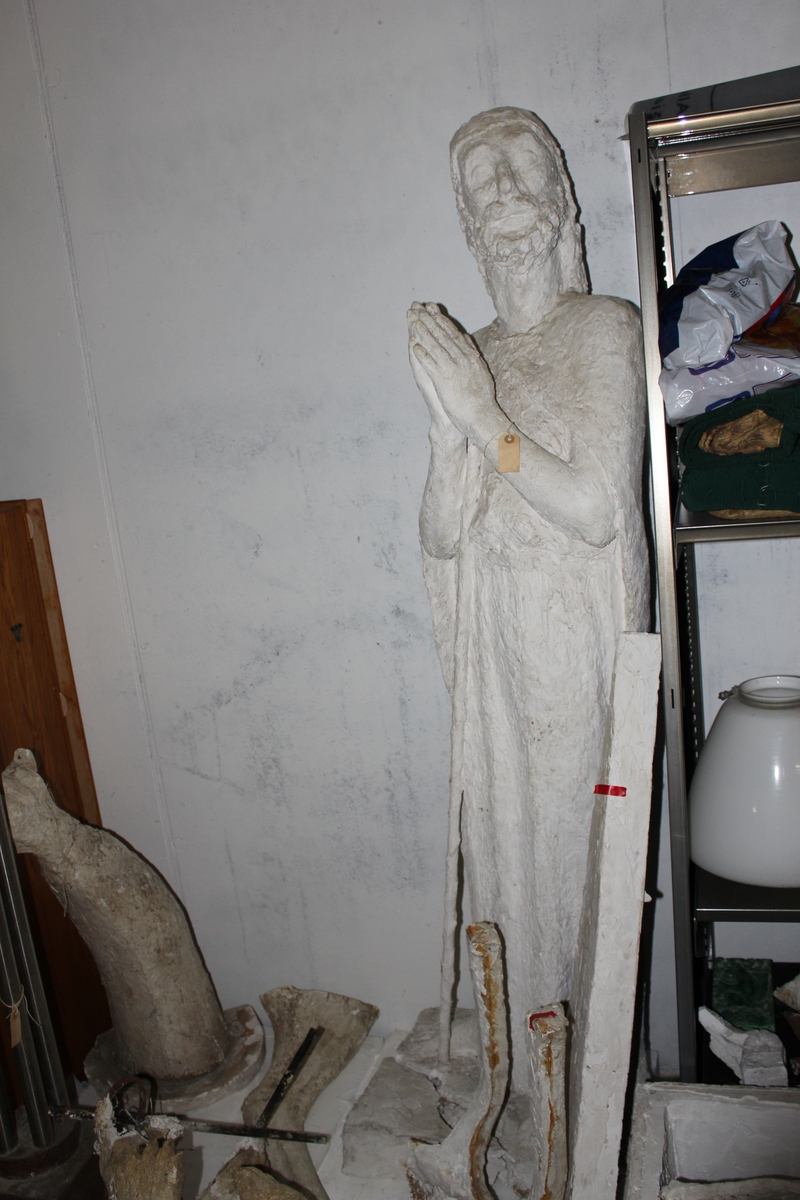 Skulptur i gips av en mann i kjortel med stokk. Tittel "Emmausvandrerne". Se også nr.261 og nr.263