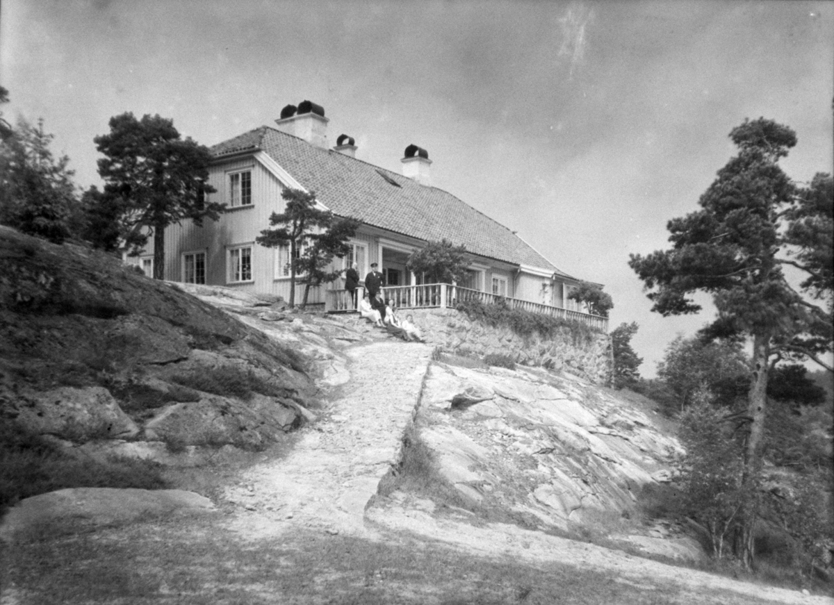 "Bloksberg" på Hankø. Eksteriør. Familie sittende på trappa opp til huset. Bestiller: C. B. Thorne.