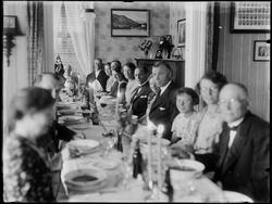 Stueinteriør med kvinner og menn, festpyntet. Ukjent.
Maler