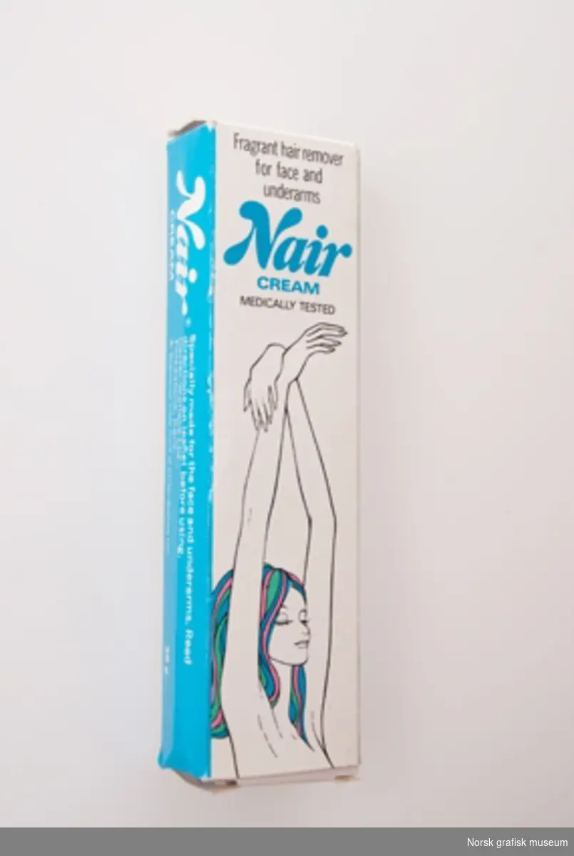 Eske med blå og sort trykk på hvit bunn. Har inneholdt hårfjerningskremen "Nair".
