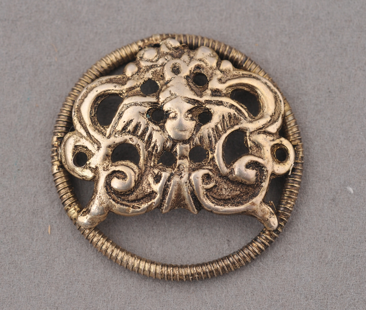 Male sett saman av ring laga av skruvetråd med fastlodda støypt ornament som har englemotiv i senter.