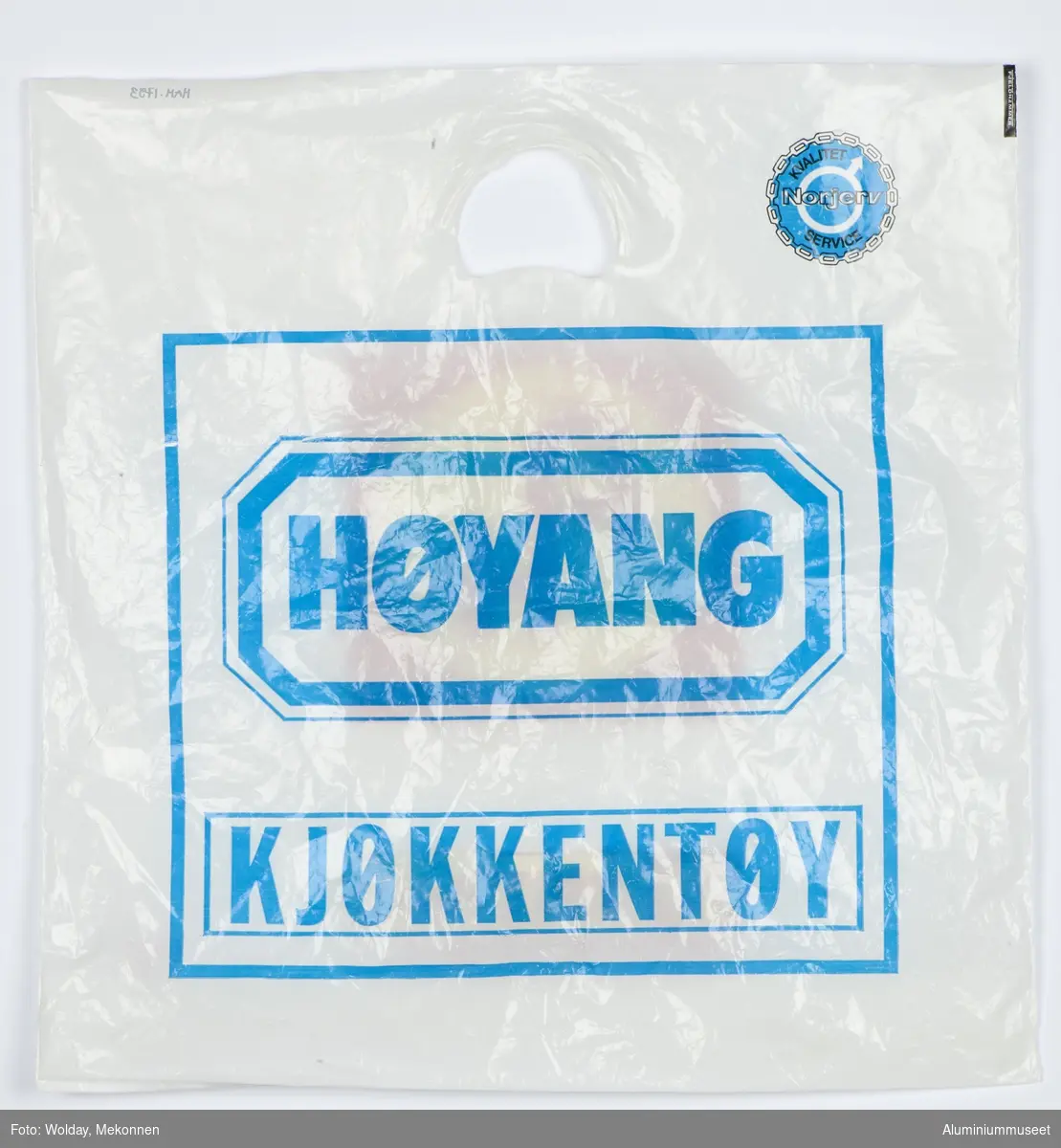 Hvit bærepose med Høyanglogo i blått på ene siden, den andre med Holmestrand Jern &Farvehandel as