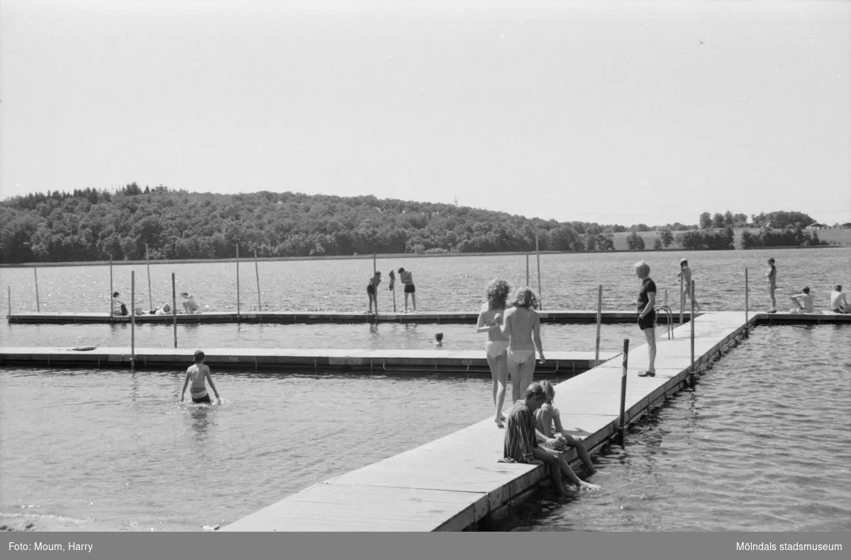 Människor som badar vid Tulebo Strandväg (Tulebosjöns sandstrand) i Kållered år 1984. Den är nu nedlagd. I bakgrunden ses den nya badplatsen vid Stretered.
