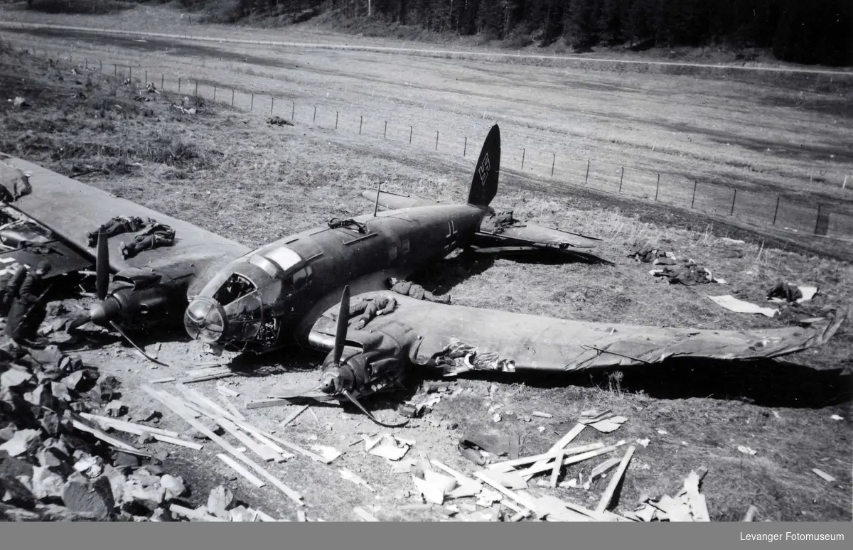 Tyske soldater hviler på og rundt vraket av et bombefly av typen Heinkel 111.
