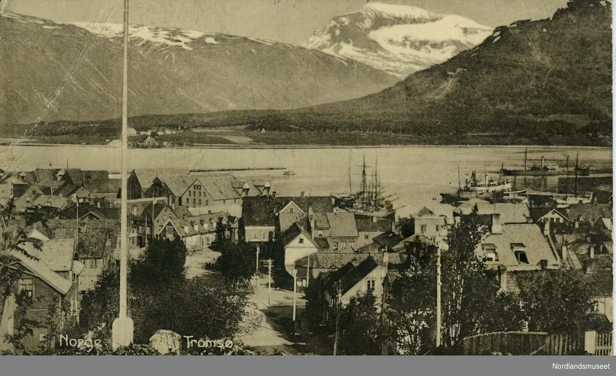 Oversiktsbilde fra postkort over Tromsø. Bygninger og flaggstang foran, fjord og snødekte fjell bak.

Bakside: Grønt postfrimerke, posthorn, 5 øre. Stemplet Svolvær 23.05.1917.