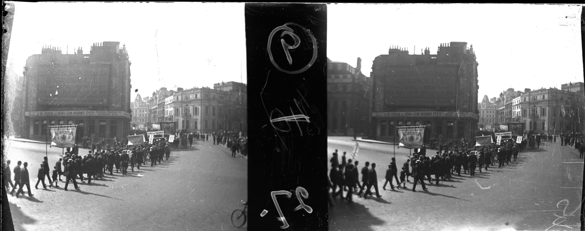 'Bildtext: ''Trade union´s procession, Trafalgar Square.'' :: Gatuvy med folksamling män och kvinnor, ev. demnstrationståg. ::  :: Ingår i serie med fotonr. 5263:1-16. Se även hela serien med fotonr. 5237-5267.'