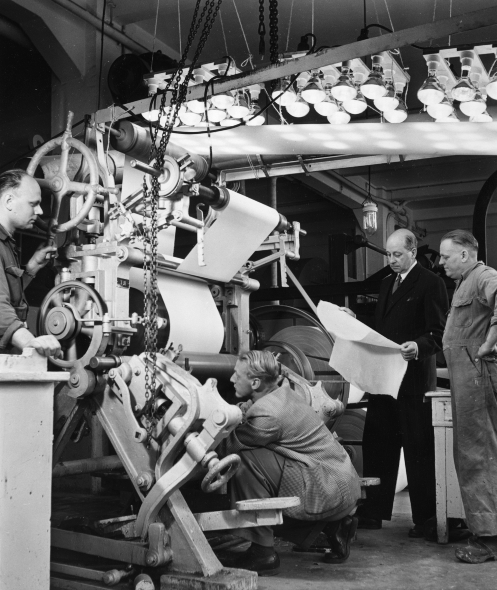 Fyra män arbetar vid djuptrycksmaskin T18 på Papyrus, okt. 1951. Arne Ahlström, Ingenjör Danielsson, Gunnar Lalin, Einar Floberg