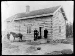 Familie på trappa til et tømmerhus