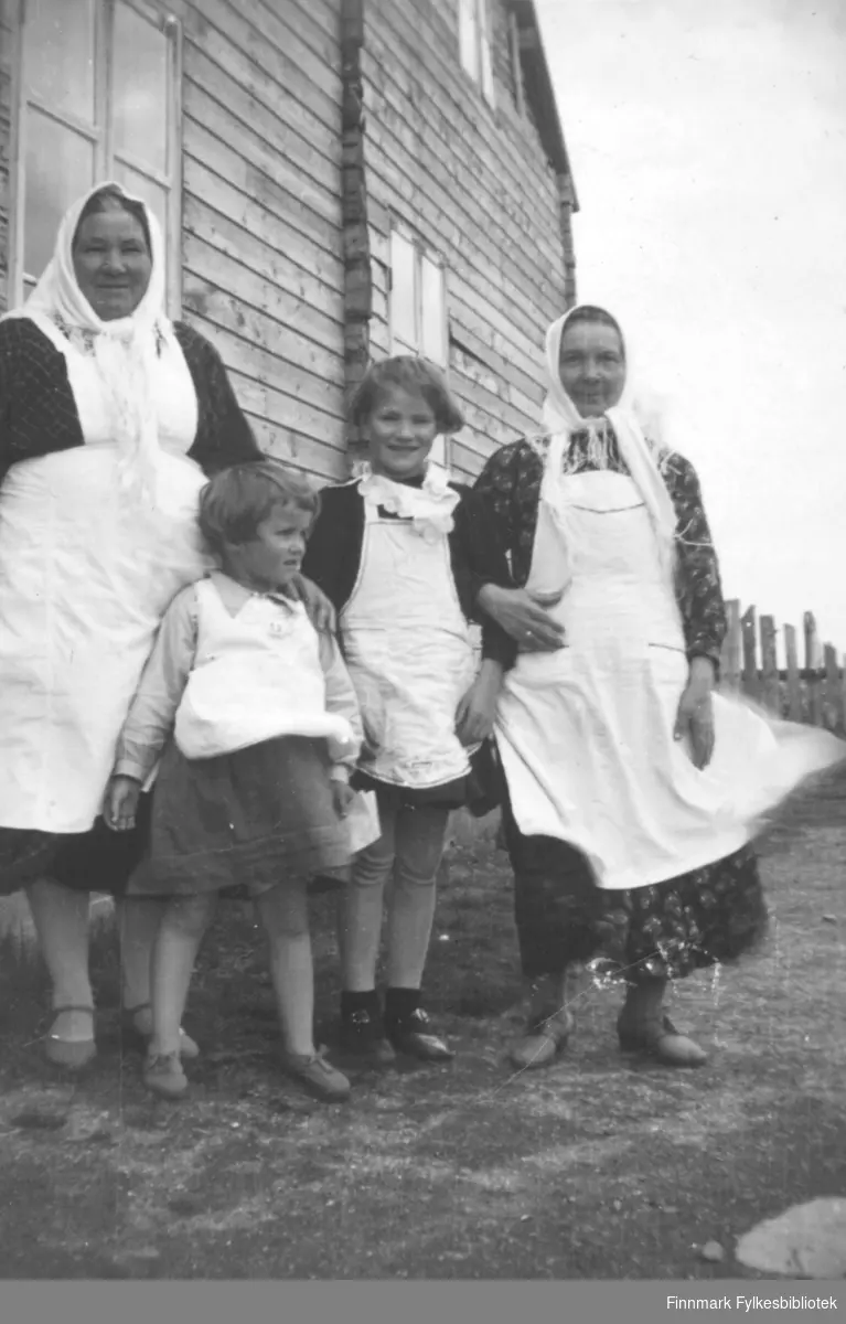 To damer og to jenter fotografert utenfor et bygg i Nyhamn i Vadsø kommune rundt 1940. De er: Helga Larsen, Selma Ridola, Åshild Heggli og Ingrid Therese Niskavara.