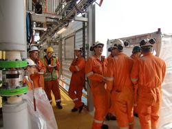 En gruppe arbeidere er samlet på et plattformdekk for å feir